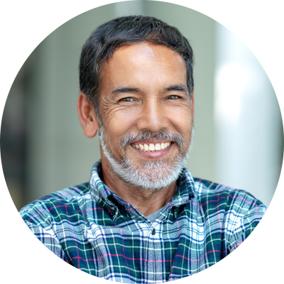 A smiling older fellow with a plaid shirt and beard.