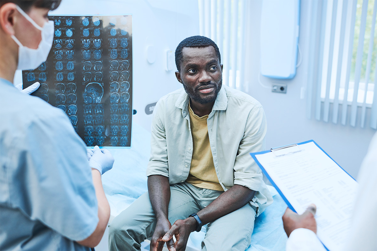 A man awaits a procedure while the doctor reads a translated medical device