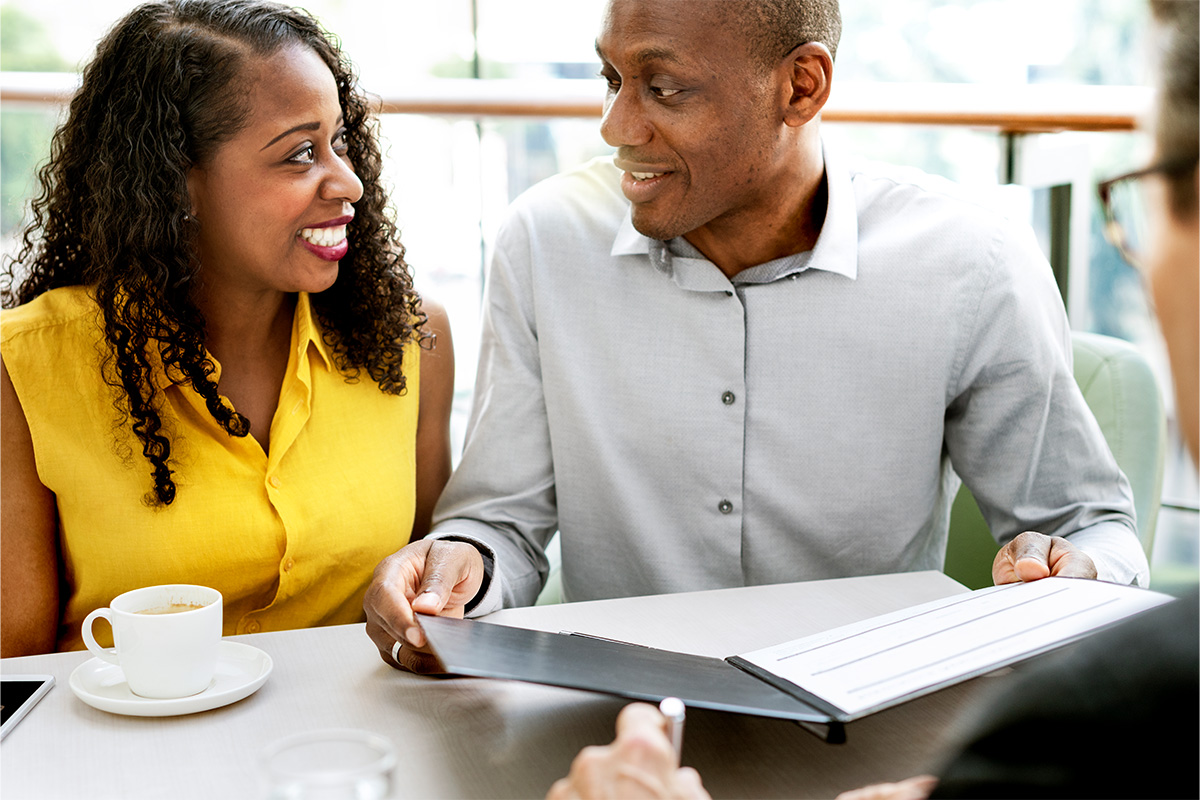 An excited couple review their Ad Astra translated auto insurance policy