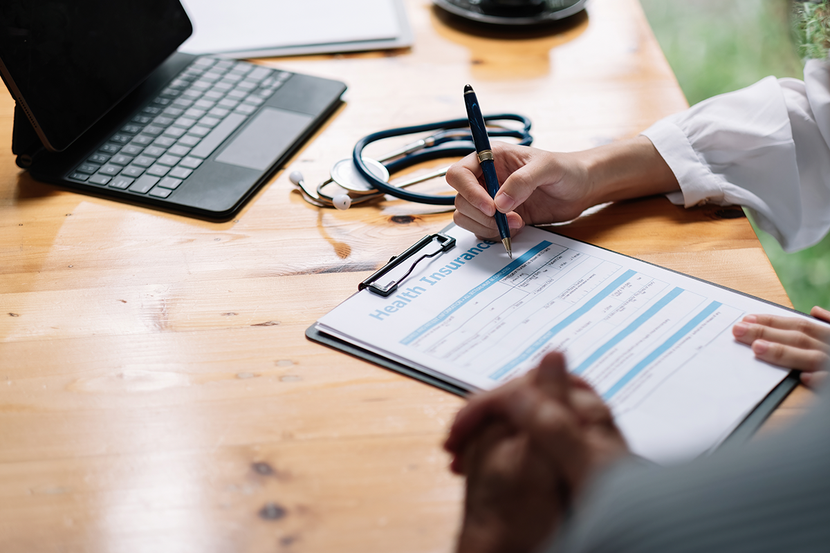 In an office, a doctor explains to his patients the points of their health insurance.