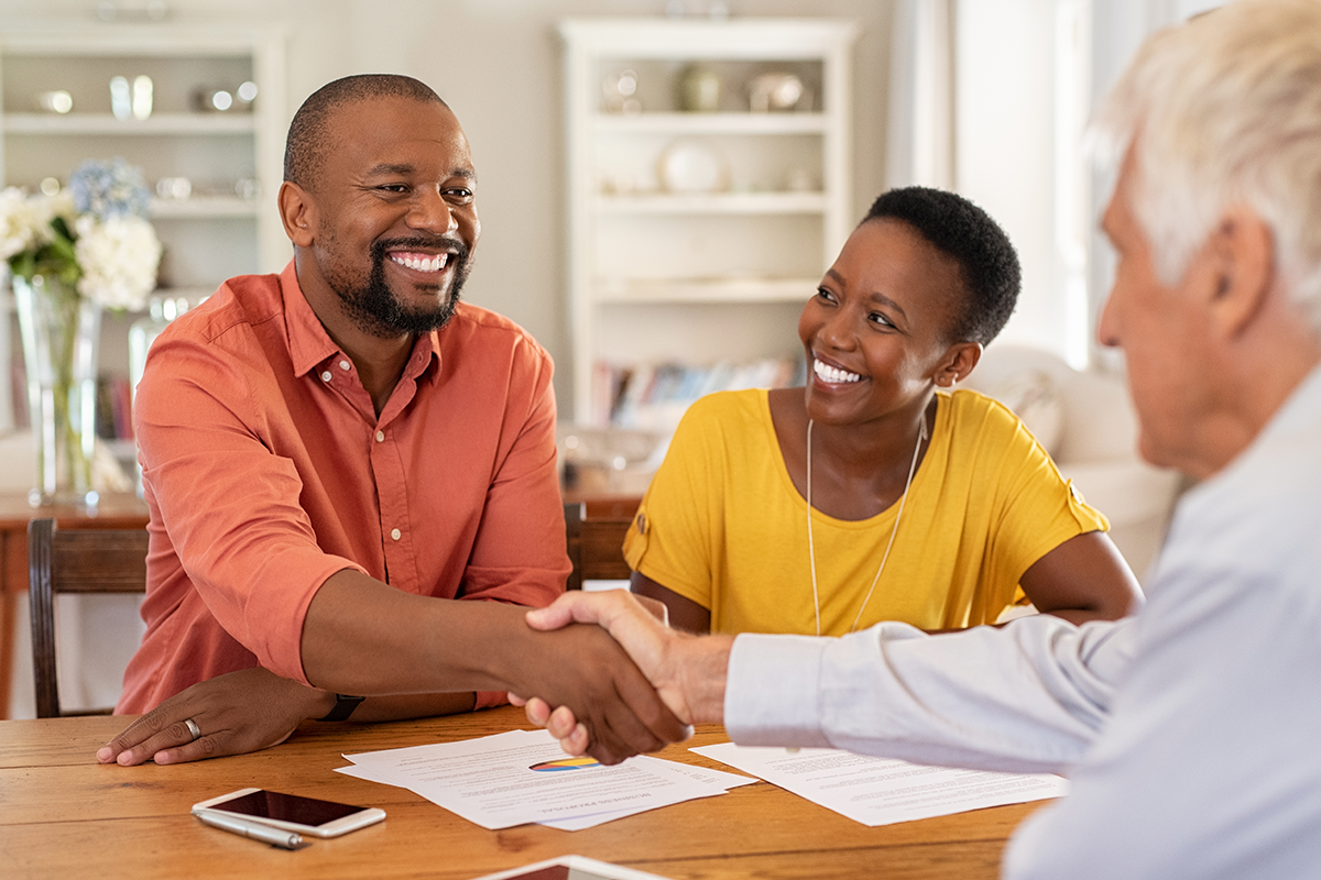 A family signs a contract with an insurance company to protect their first home.